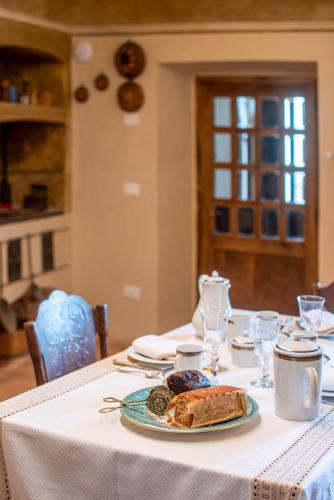 a white table with a plate of food on it at Palazzo D'Alessandro Wunderkammer & Suites B&B di charme in Caporciano