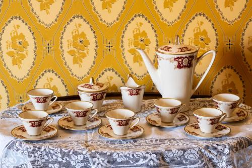 a group of cups and saucers on a table at Palazzo D'Alessandro Wunderkammer & Suites B&B di charme in Caporciano