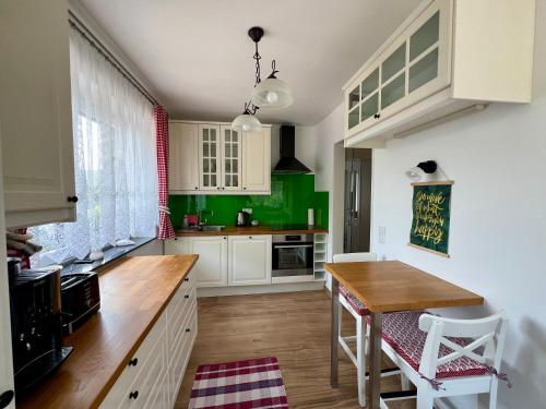 a kitchen with green cabinets and a wooden table at Apartments Sunnseitn by Gerrit & Herfried in Krumpendorf am Wörthersee