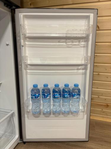 a refrigerator filled with bottles of water at Wooden House Martvili in Martvili