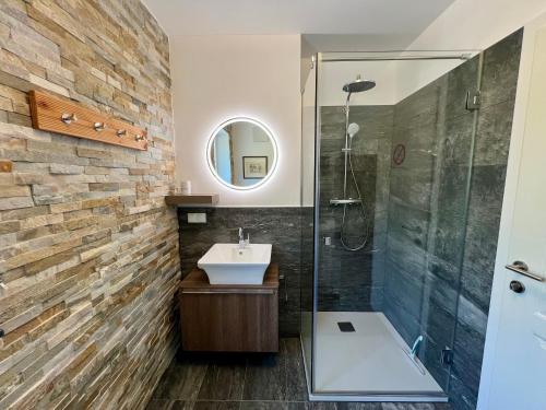 a bathroom with a sink and a glass shower at Apartments Sunnseitn by Gerrit & Herfried in Krumpendorf am Wörthersee