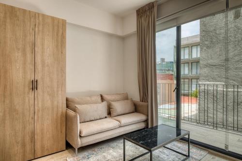 a living room with a couch and a glass table at Myla Chapultepec in Mexico City