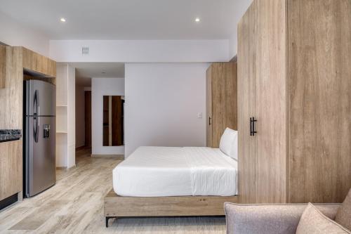 a bedroom with a white bed and wooden cabinets at Myla Chapultepec in Mexico City