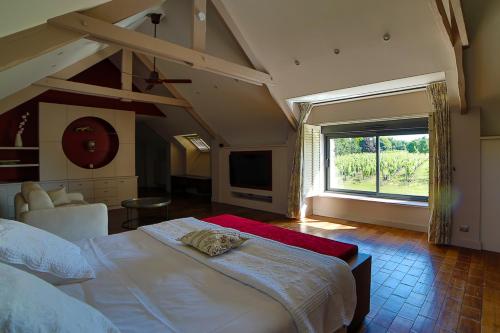 a bedroom with a large bed and a large window at Luxueuse Longère 350m2 "Le Grand Kerfra" au Vignoble Domaine Lamballe, Baden, Golfe du Morbihan in Baden