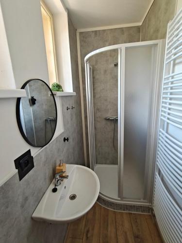 a bathroom with a sink and a shower and a mirror at Vila Mezi Časy in Trutnov