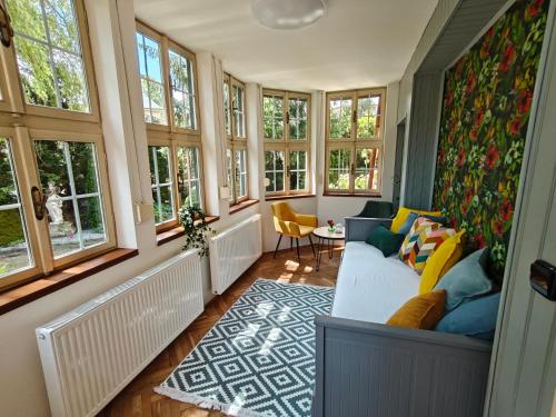 a living room with windows and a couch at Vila Mezi Časy in Trutnov