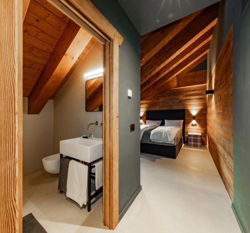 a bathroom with a sink and a bed in a room at La Tana Lodge & SPA in La Colla