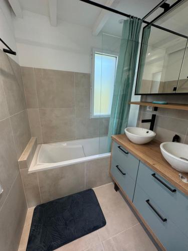 une salle de bain avec deux lavabos et une baignoire et une baignoire dans l'établissement Villa Pyla sur Mer, à La Teste-de-Buch