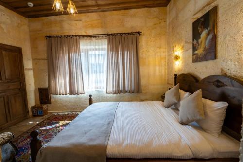 a bedroom with a large bed and a window at Library Cave House in Urgup