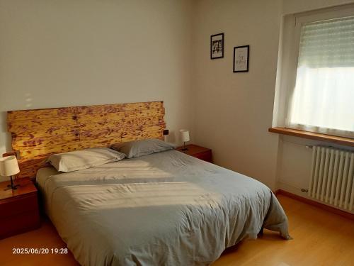 a bedroom with a large bed with a wooden headboard at ~ La Villetta Gialla ~ Casa al centro del F.V.G in Rodeano Basso