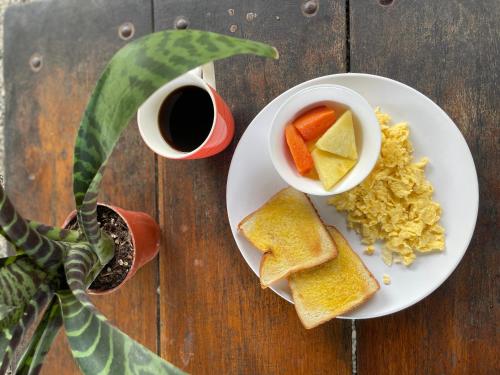 un piatto di uova e pane tostato e una ciotola di frutta di Kalunay Hostel a Puerto Viejo