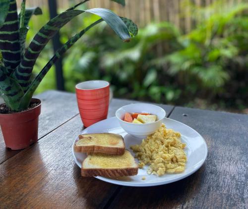 un piatto di prodotti per la colazione con uova e pane tostato di Kalunay Hostel a Puerto Viejo