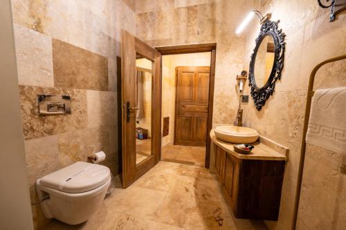 a bathroom with a toilet and a sink and a mirror at Library Cave House in Urgup