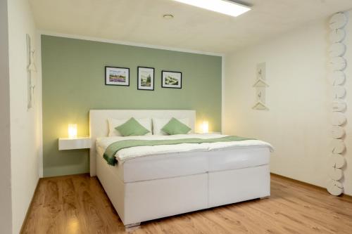 a bedroom with a white bed with two lights on it at Gemütliche Ferienwohnung "Zum Kalten Feld" in Schwäbisch Gmünd