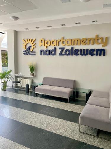 a waiting room with two couches and a sign on a wall at Apartament Navy Blue z tarasem in Serock