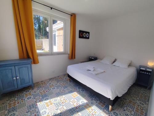 ein Schlafzimmer mit einem weißen Bett und einem Fenster in der Unterkunft La 08 maison de vacances in Fort-Mahon-Plage