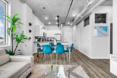 a living room with a table and blue chairs at Chic 2BR Getaway Walk to Breweries and Art Walk in St Petersburg