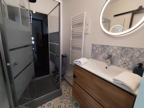 ein Badezimmer mit Dusche, Waschbecken und Spiegel in der Unterkunft La 08 maison de vacances in Fort-Mahon-Plage