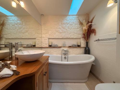 a bathroom with a large tub and a sink at Solenzia, appartement luxueux à 100m de la plage in Saint-Tropez