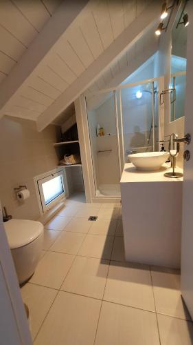 a white bathroom with a sink and a toilet at villa Séléné in Sivota