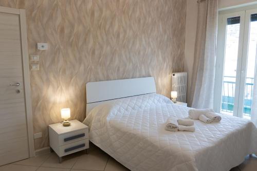 a bedroom with a white bed with towels on it at Luma Casa Vacanze in Gaeta