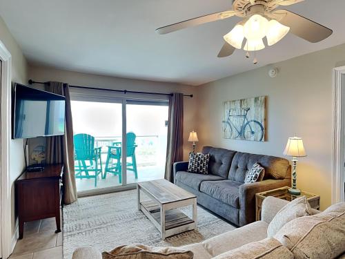 a living room with a couch and a tv at Regency Towers #302 West in Pensacola Beach