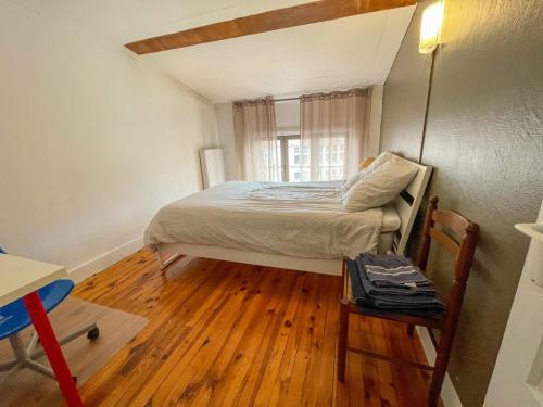 - une petite chambre avec un lit et du parquet dans l'établissement Le Saint'& Color - WIFI - close to city center - T3, à Saint-Étienne