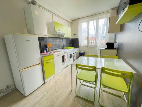 une cuisine avec une table, des chaises et un réfrigérateur dans l'établissement Le Saint'& Color - WIFI - close to city center - T3, à Saint-Étienne