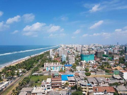 マウントラビニアにあるOptions Beach Guest House Dehiwala-Mount Laviniaのビーチや建物のある街の景色を望めます。