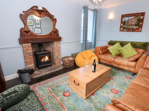 a living room with a couch and a fireplace at Rosemary Cottage in Leyburn