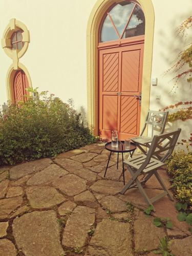a patio with a chair and a table and a door at Bergmanns Lieblingsplatz in Freiberg