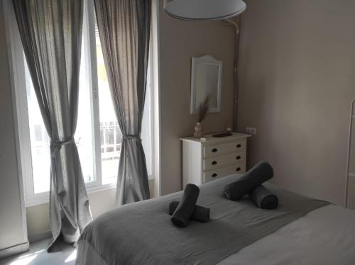 a bedroom with a bed with two pillows and a window at Plaza Plateros in Jerez de la Frontera