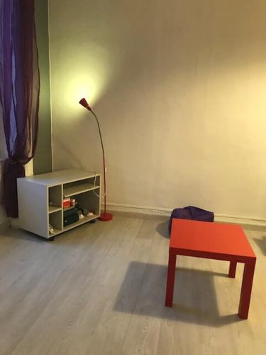 une chambre avec une chaise rouge et une lampe dans l'établissement Studio idéalement placé, calme et proche centre ville, à Saint-Étienne