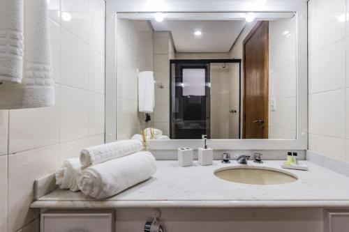 Un baño blanco con lavabo y espejo. en Positano by My Way, en Porto Alegre