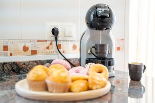 a plate of donuts on a counter next to a mixer at Adosado con piscina cerca de Castellón y Benicàssim a 10 min andando de la playa in Almazora
