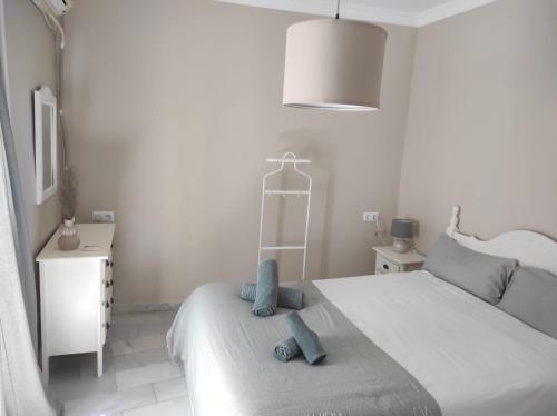 a bedroom with a bed with two blue towels on it at Plaza Plateros in Jerez de la Frontera