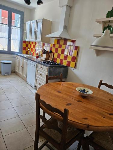 - une cuisine avec une table en bois, des chaises et une cuisinière dans l'établissement Les Reflets de l 'Indre, à Loches