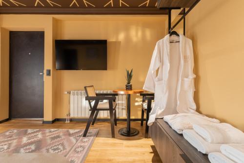 a room with a bed and a table and a tv at Agara Stays Prizren in Prizren