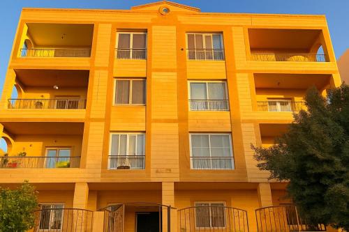 an orange building with balconies on it at Stylish 2BR Flat - El Shorouk, Near Madinaty in Madīnat ash Shurūq
