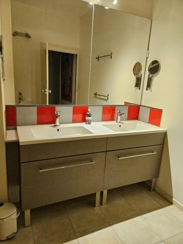 une salle de bain avec deux lavabos et un grand miroir dans l'établissement Les Reflets de l 'Indre, à Loches