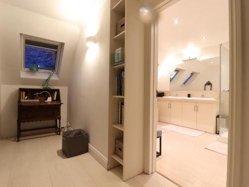 a bathroom with a sink and a desk in a room at Forest Getaway in Slough