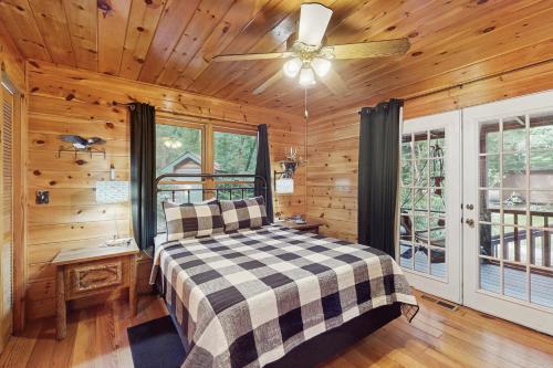 a bedroom with a bed and a ceiling fan at Trout House in Mineral Bluff
