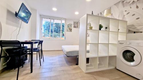 una cucina e una sala da pranzo con tavolo e lavatrice di Apartamentos Gamonal Costa del Sol a Málaga