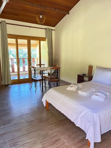 a bedroom with a bed and a table with chairs at Recanto Das Borboletas in São Roque