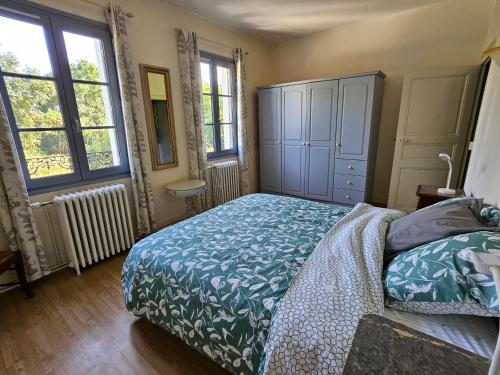 une chambre avec un lit et une commode et deux fenêtres dans l'établissement Les Reflets de l 'Indre, à Loches