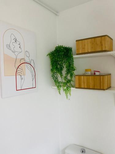 une salle de bains avec une plante verte sur un mur dans l'établissement Le Gatsby - Hypercentre, Parking, Netflix, Calme, à Poitiers