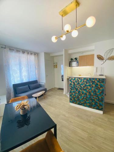 un salon avec un canapé bleu et une table dans l'établissement Le Gatsby - Hypercentre, Parking, Netflix, Calme, à Poitiers