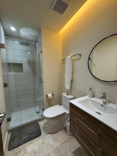 a bathroom with a shower and a toilet and a sink at Loft apartment in a private condominium in Tulum