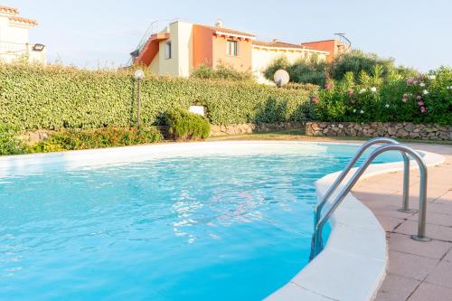 a swimming pool in front of a house at Green Residence Bados Mare in Olbia