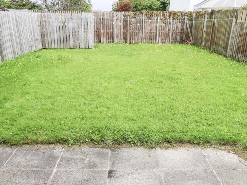 a backyard with a fence and a green yard at 22 White Maples in Bundoran
